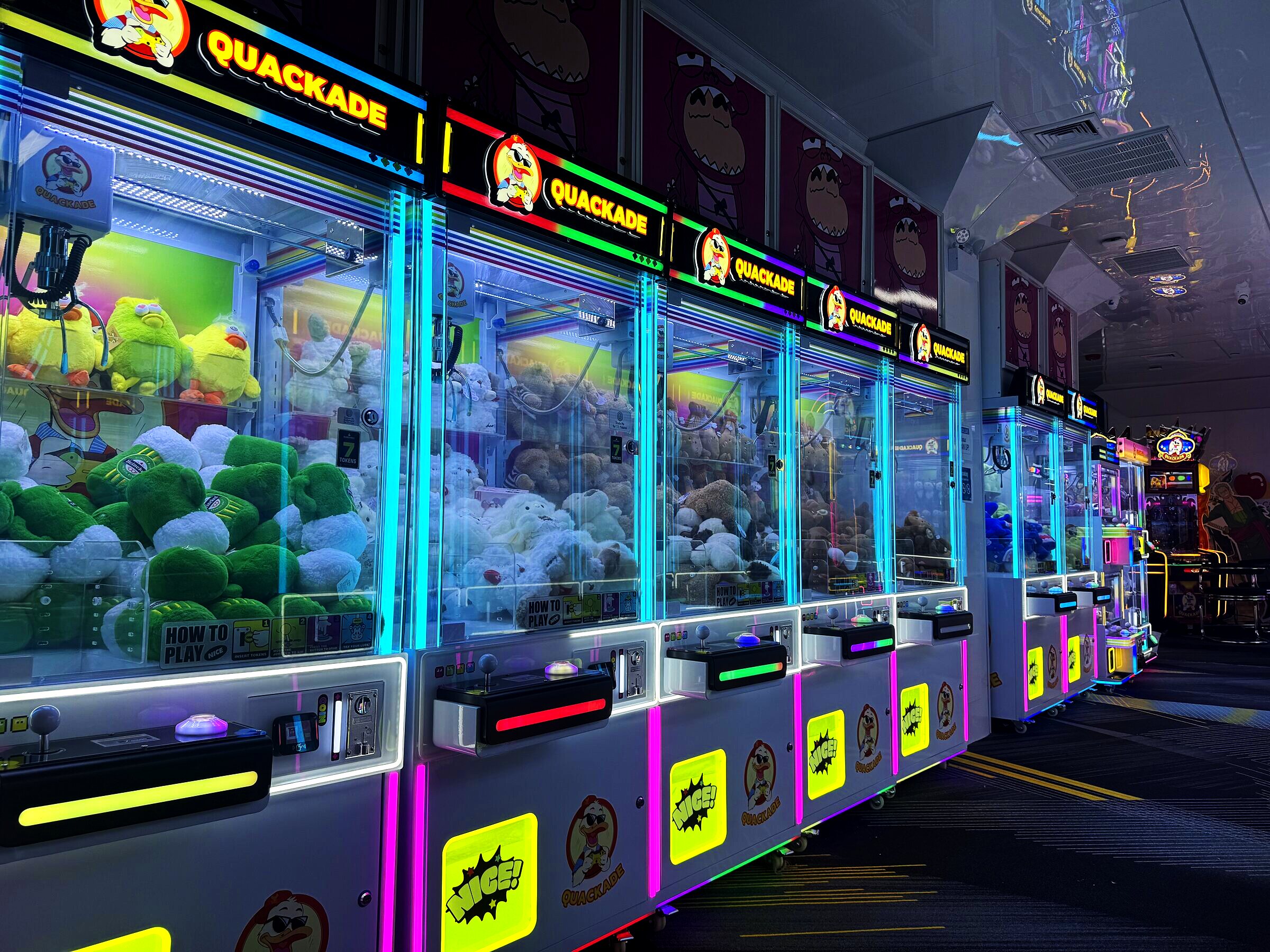 Row of Quackade claw machines filled with plush prizes